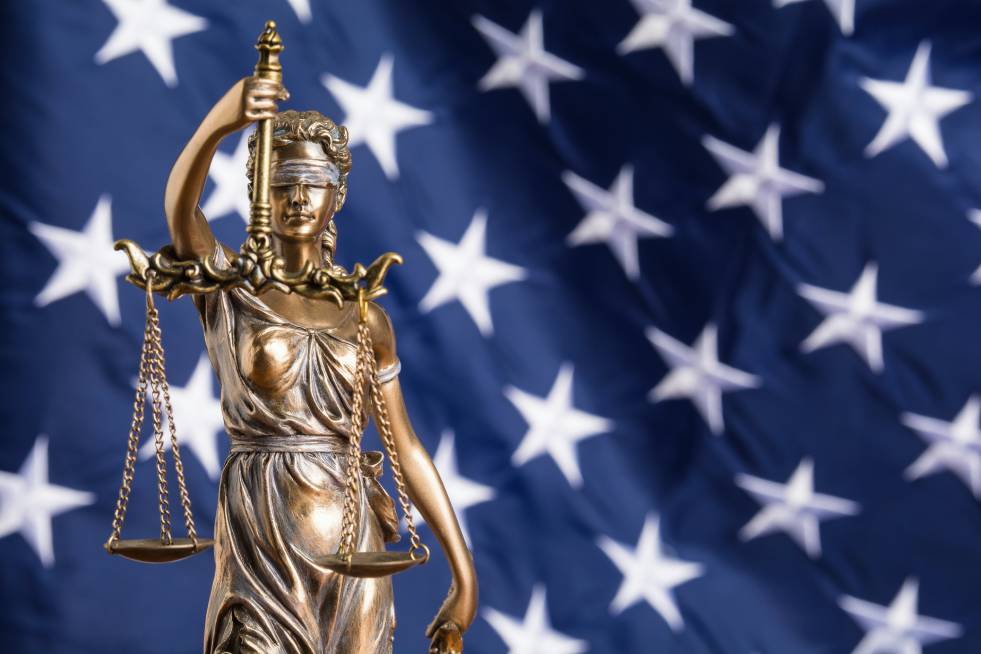 Lady Justice with scale in front of flag